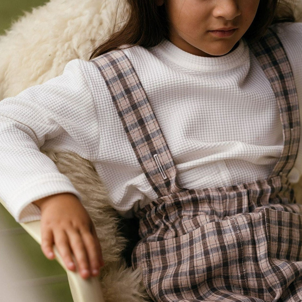 brown check linen trousers with matching adjustable braces.  Worn with an offwhite waffle organic jersey long sleeve round neck child's top