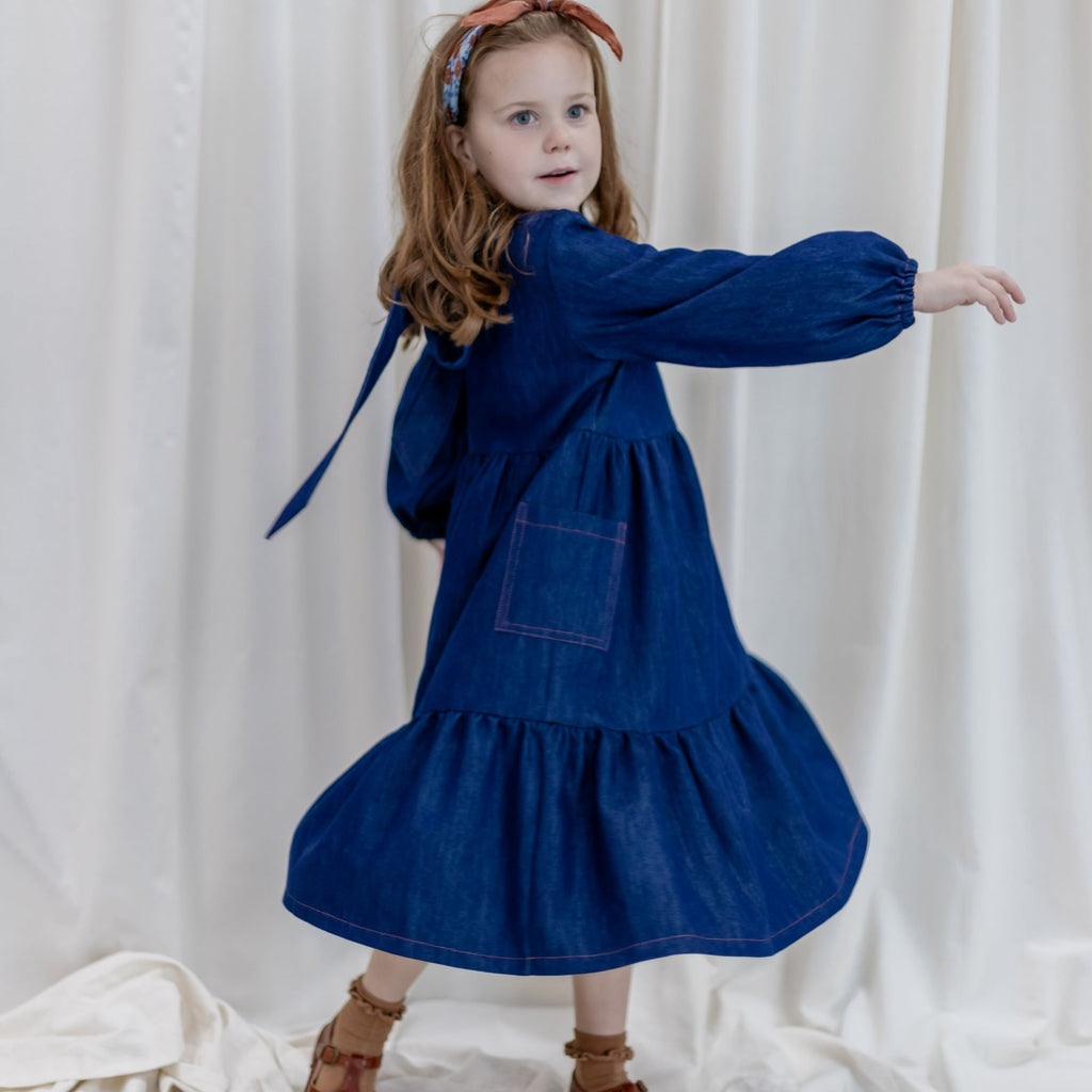 girls blue denim dress with tiered skirt, long puff sleeves and option to wear with ties at front or back