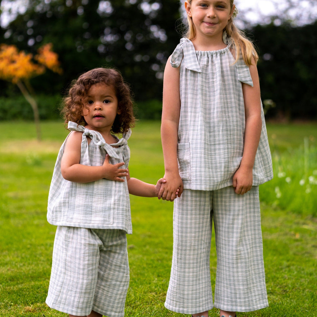 Image shows 2 girls wearing the mint gingham girls swing top with bow shoulder detail worn with the Quinn unisex kids culottes in mint gingham