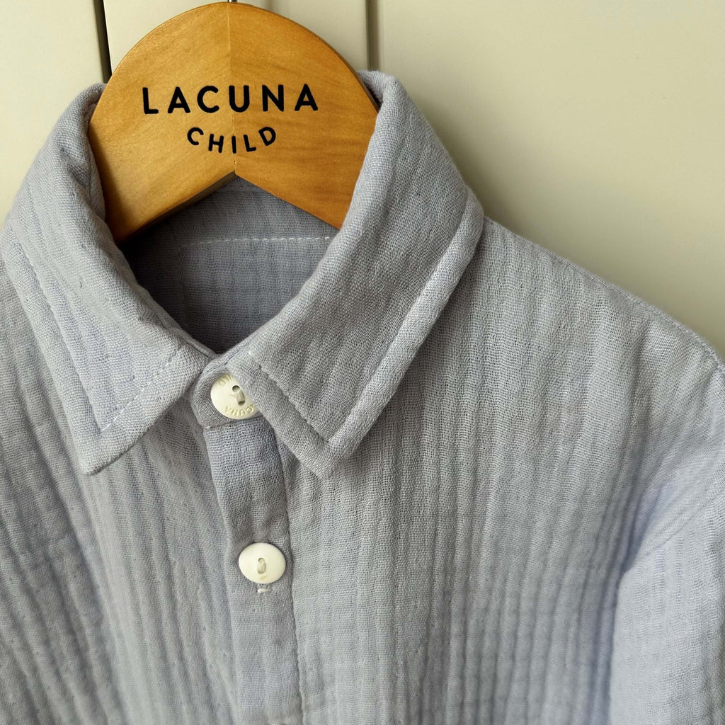 Closeup image of the organic triple muslin childrens Bailey shirt in pale blue. The most beautiful shade on both boys and girls. Shown the offwhite button and shirt collar