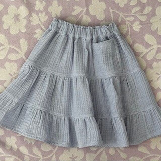 Girls blue triple gauze knee length muslin tiered skirt.  Look completed with a large pocket.